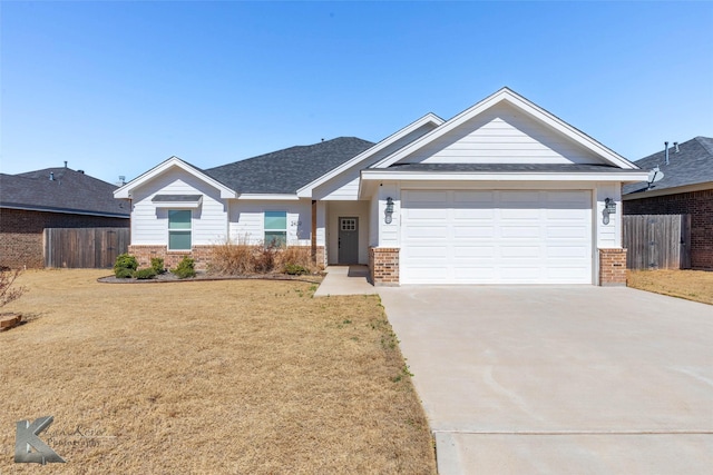 view of front facade featuring driveway, brick siding, an attached garage, and fence