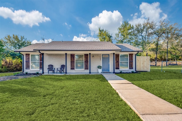 view of front of house featuring brick siding, a front yard, and fence