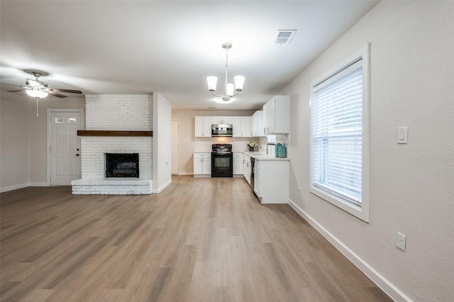 kitchen featuring electric range, visible vents, light wood-style floors, white cabinets, and stainless steel microwave