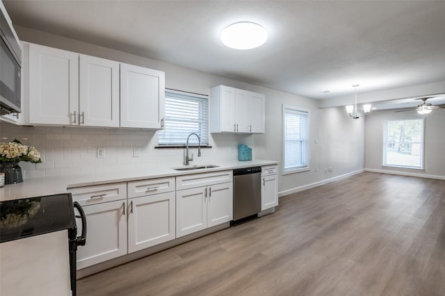 kitchen featuring tasteful backsplash, stainless steel appliances, light wood-type flooring, white cabinetry, and a sink