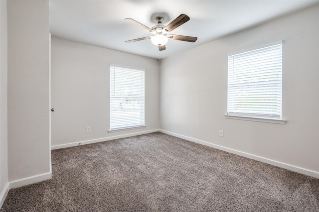 carpeted empty room with a healthy amount of sunlight, ceiling fan, and baseboards