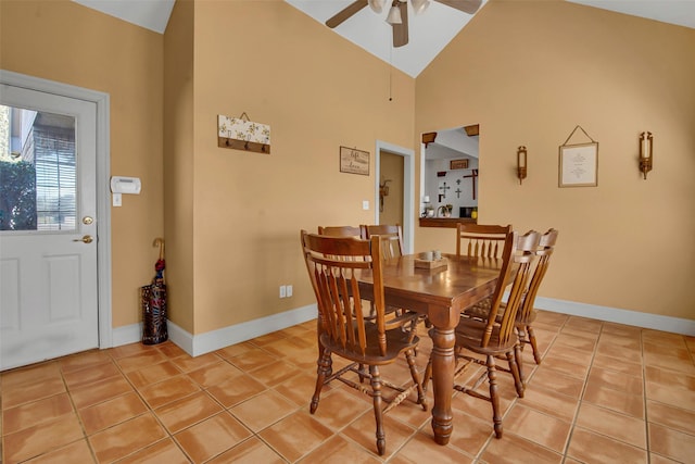 dining room with light tile patterned floors, ceiling fan, high vaulted ceiling, and baseboards