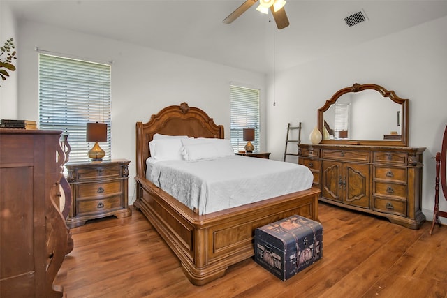 bedroom featuring wood finished floors, visible vents, and ceiling fan