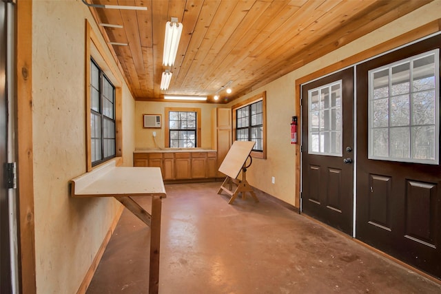 foyer entrance featuring wooden ceiling, an AC wall unit, and concrete floors