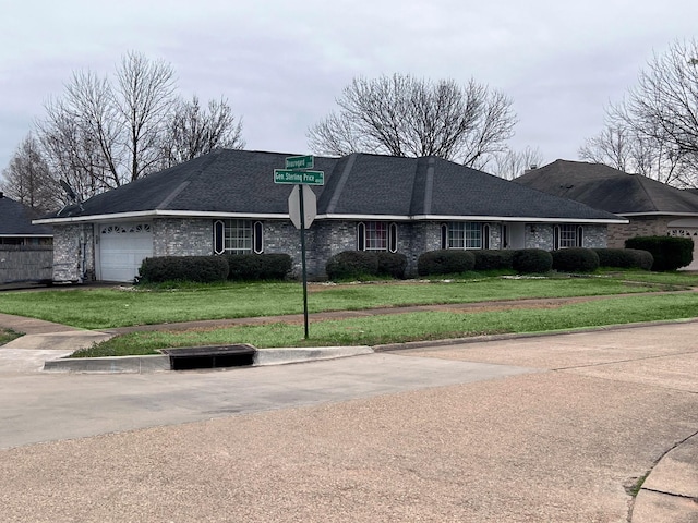 view of front of house featuring an attached garage, a front lawn, and brick siding