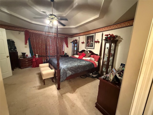 bedroom featuring a ceiling fan, a raised ceiling, and ornamental molding