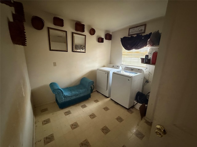 clothes washing area with light floors, laundry area, and separate washer and dryer