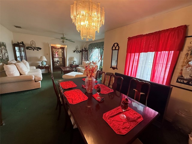 carpeted dining room featuring ceiling fan with notable chandelier and visible vents