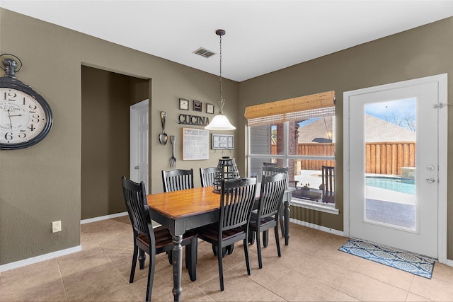 dining space featuring light tile patterned floors, visible vents, and baseboards