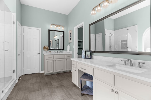 full bath with wood finished floors, a stall shower, and vanity