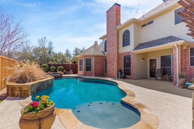 view of swimming pool with a pool with connected hot tub, a fenced backyard, and a patio area