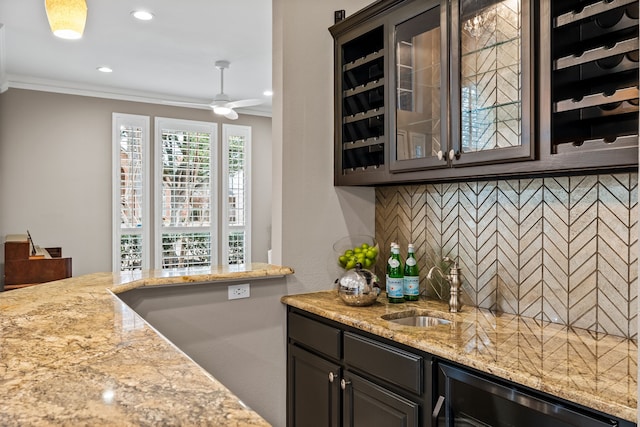 kitchen with glass insert cabinets, crown molding, a sink, and tasteful backsplash