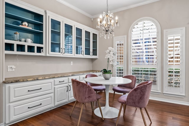 dining room with dark wood-style floors, a chandelier, and crown molding