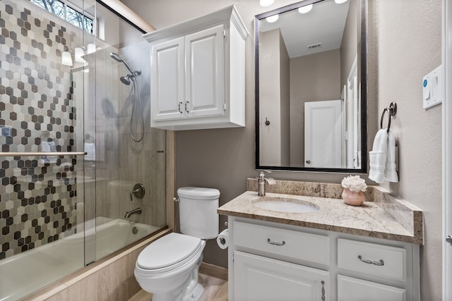 full bathroom with enclosed tub / shower combo, toilet, vanity, and visible vents