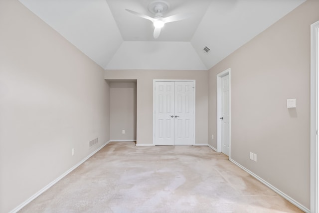 unfurnished bedroom with light colored carpet, lofted ceiling, visible vents, and baseboards