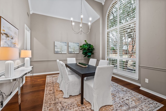 dining space featuring crown molding, dark wood-style flooring, baseboards, and an inviting chandelier