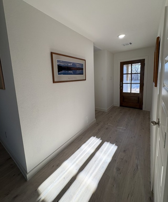 interior space featuring wood finished floors, visible vents, and baseboards