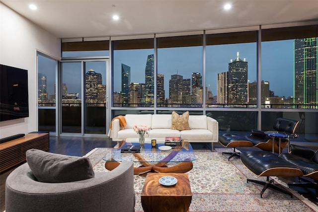 living room featuring a city view, floor to ceiling windows, and wood finished floors