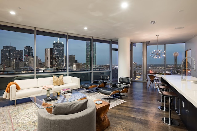 living room featuring a view of city, wood finished floors, visible vents, expansive windows, and an inviting chandelier