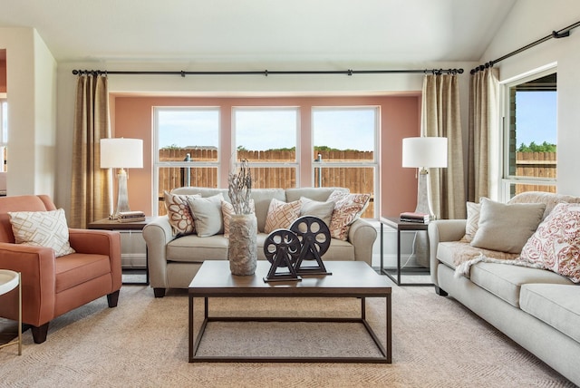 living room featuring a healthy amount of sunlight, light carpet, and vaulted ceiling