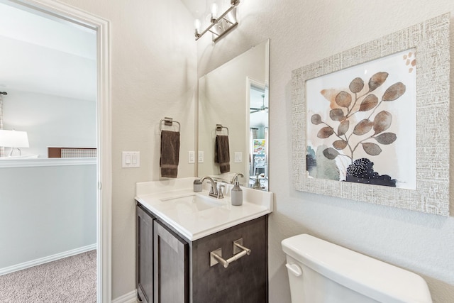 bathroom with vanity, toilet, and baseboards