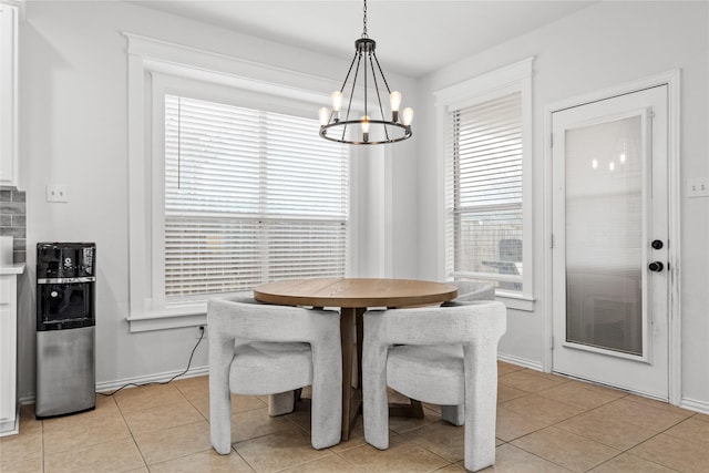 dining area with light tile patterned floors, baseboards, and an inviting chandelier