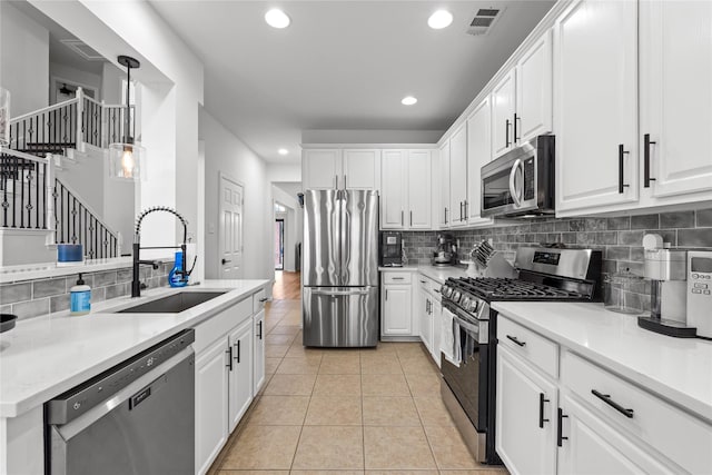 kitchen with visible vents, light tile patterned flooring, a sink, appliances with stainless steel finishes, and white cabinetry