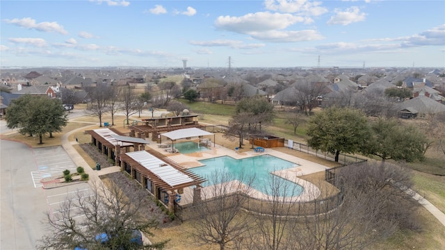 community pool with a patio area, a residential view, a community hot tub, and fence