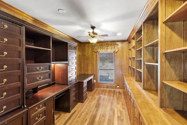 office featuring ornamental molding, light wood-type flooring, built in study area, and a textured ceiling