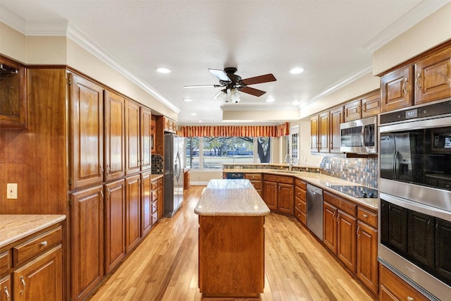 kitchen featuring stainless steel appliances, light wood-type flooring, a sink, and a peninsula