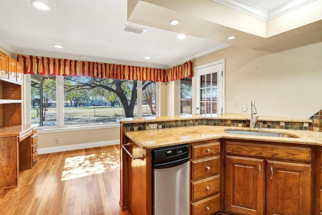 kitchen with light stone countertops, crown molding, visible vents, and a sink