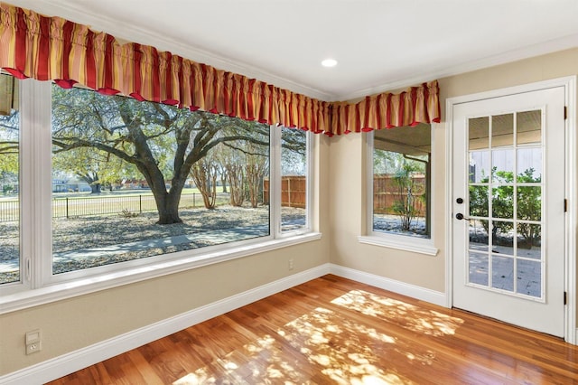 unfurnished dining area with wood finished floors and baseboards