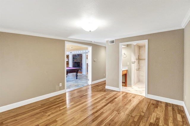 unfurnished bedroom with billiards, visible vents, baseboards, light wood-type flooring, and crown molding