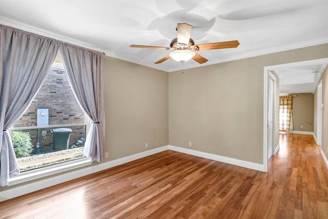 unfurnished room featuring baseboards, ceiling fan, wood finished floors, and crown molding