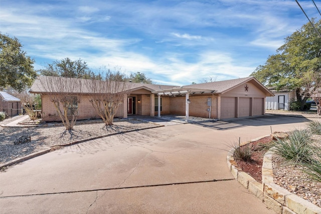 ranch-style house featuring a garage, concrete driveway, and brick siding