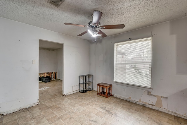 unfurnished room with visible vents, ceiling fan, and a textured ceiling