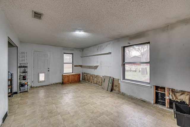 interior space with a textured ceiling and visible vents