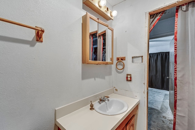 bathroom with a textured wall and vanity