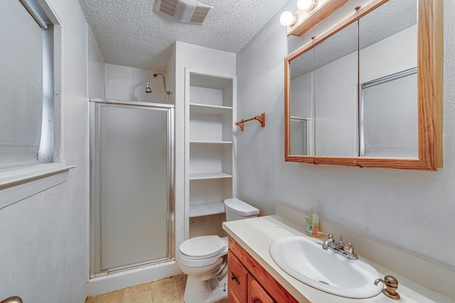 bathroom featuring toilet, a shower stall, visible vents, and a textured ceiling