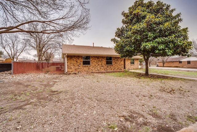 exterior space featuring brick siding and fence