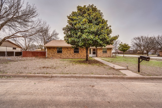 view of front of property featuring brick siding and fence