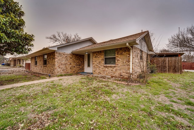 ranch-style home with a front yard and brick siding