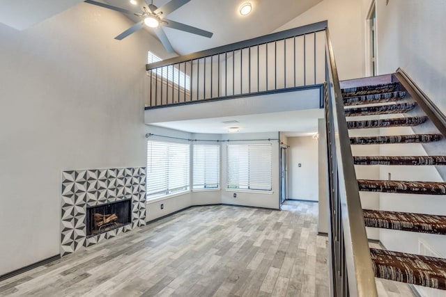 4242 N Capistrano Dr Unit 177, Dallas, TX 75287 - living room with a ceiling fan, high vaulted ceiling, stairway, and a tile fireplace