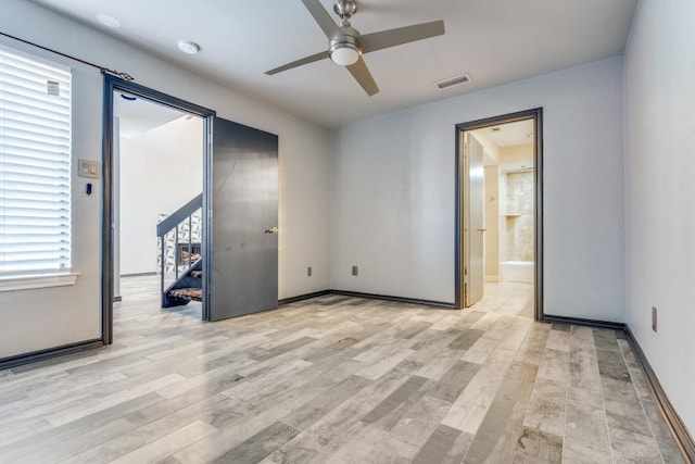 unfurnished room with visible vents, ceiling fan, light wood-style flooring, and baseboards