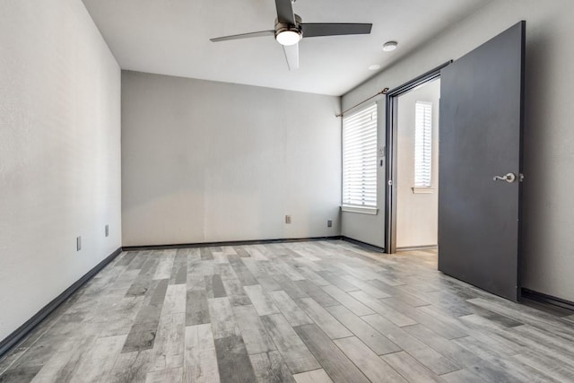 spare room with baseboards, a ceiling fan, and light wood-style floors