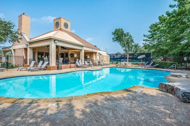 community pool featuring a patio area and fence