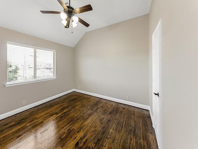 empty room featuring lofted ceiling, ceiling fan, dark wood-type flooring, and baseboards