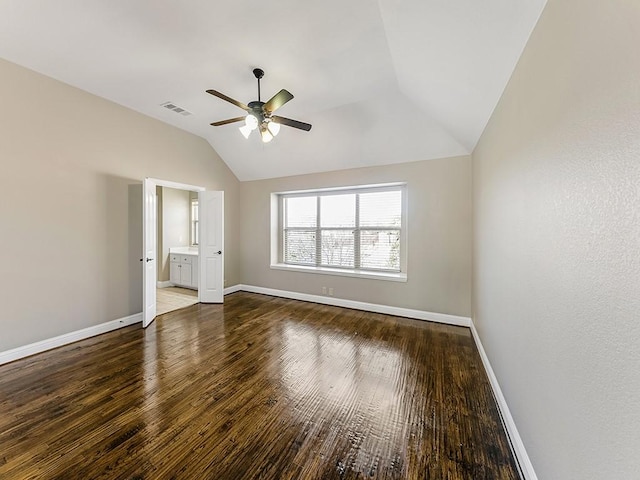 unfurnished bedroom with connected bathroom, visible vents, baseboards, vaulted ceiling, and hardwood / wood-style floors