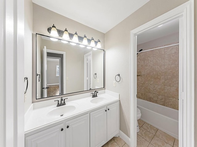 full bath featuring double vanity, a sink, toilet, and tile patterned floors