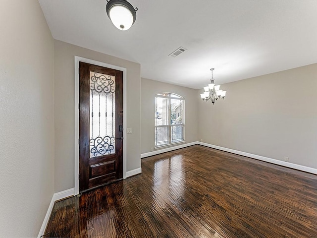 entryway featuring an inviting chandelier, wood finished floors, visible vents, and baseboards